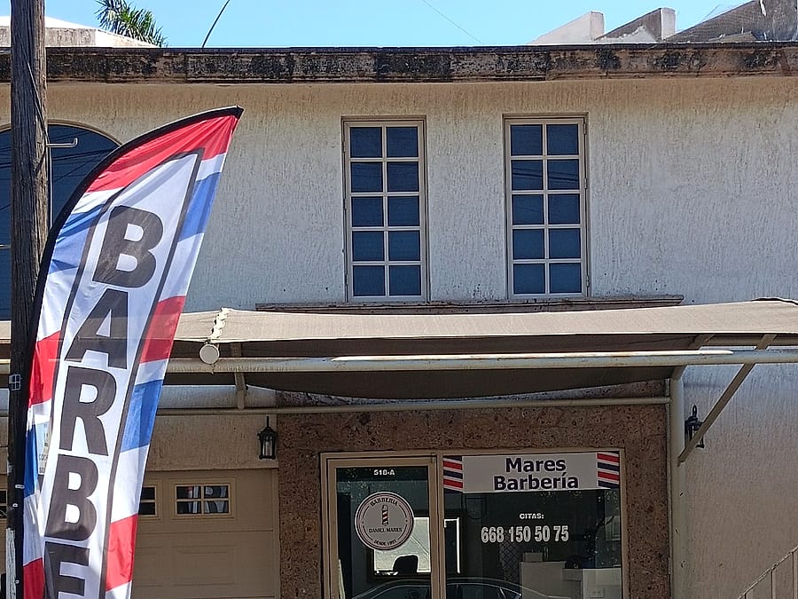 Fachada de Mares Barbería con bandera de barber shop